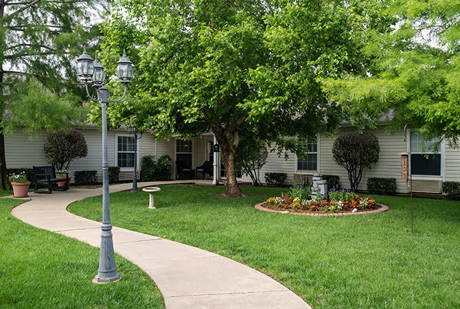 A well-maintained garden with a winding pathway and lush green surroundings.