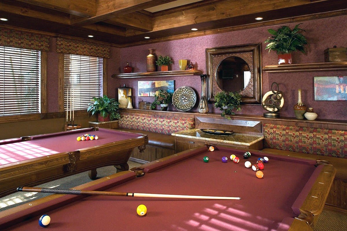 A cozy game room featuring a beautifully designed pool table with wooden accents and elegant decor.