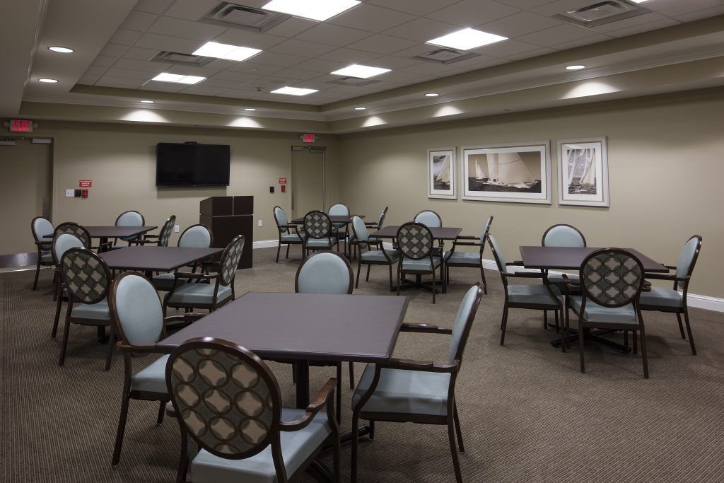 An empty conference room with tables and chairs arranged for a meeting.