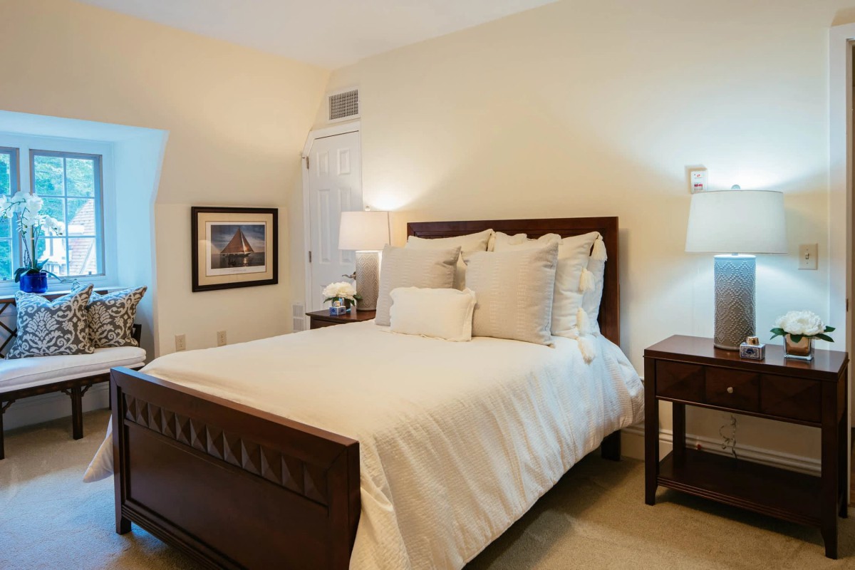 A cozy and well-decorated bedroom with a neatly made bed and warm lighting.