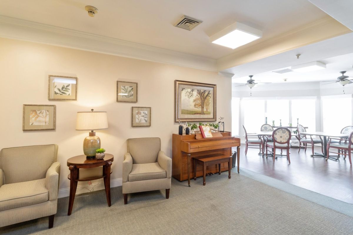A cozy living room with a piano and elegant furnishings.