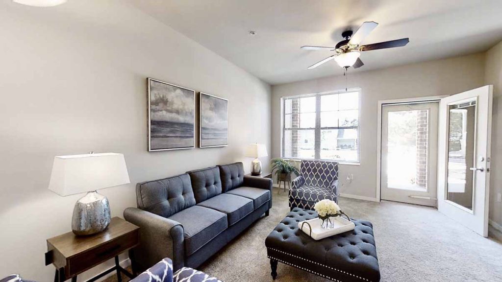 A modern living room with a comfortable sofa, patterned chair, and stylish artwork.