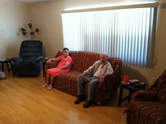Two people sitting on a couch in a living room.
