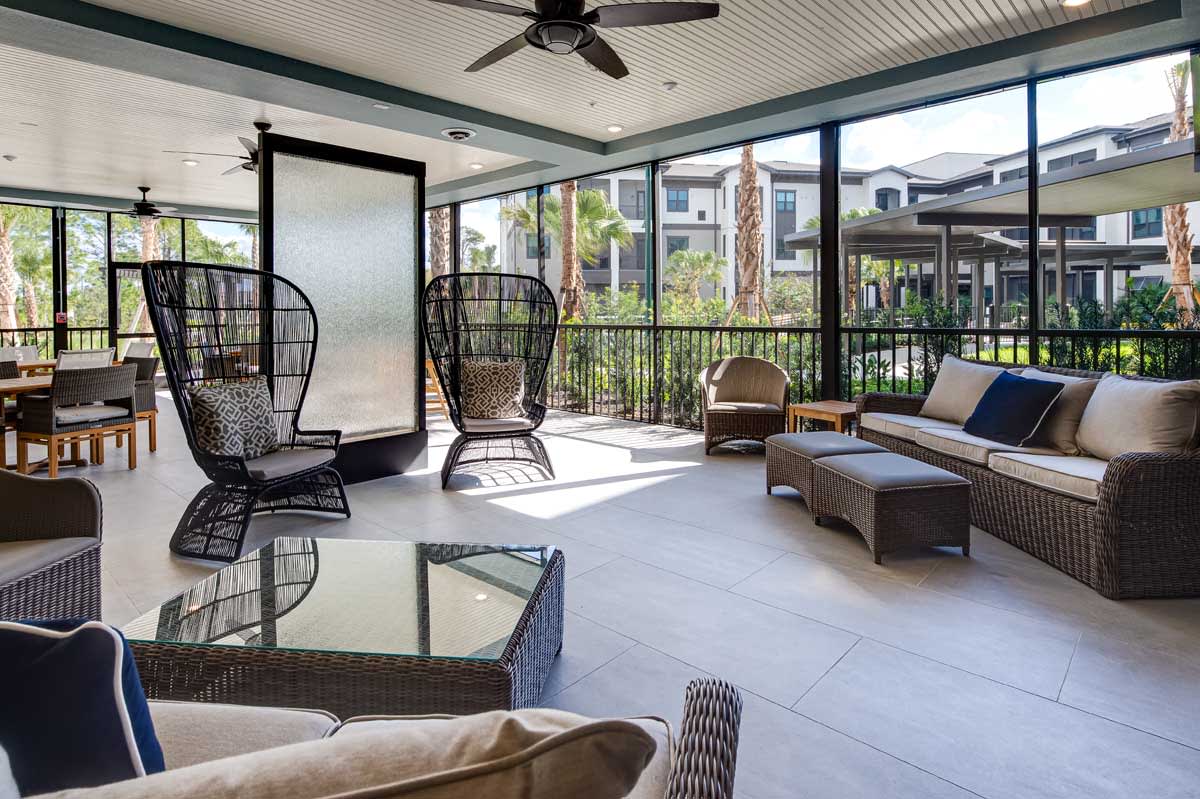 A modern outdoor patio with rattan furniture in an apartment complex, perfect for relaxation.