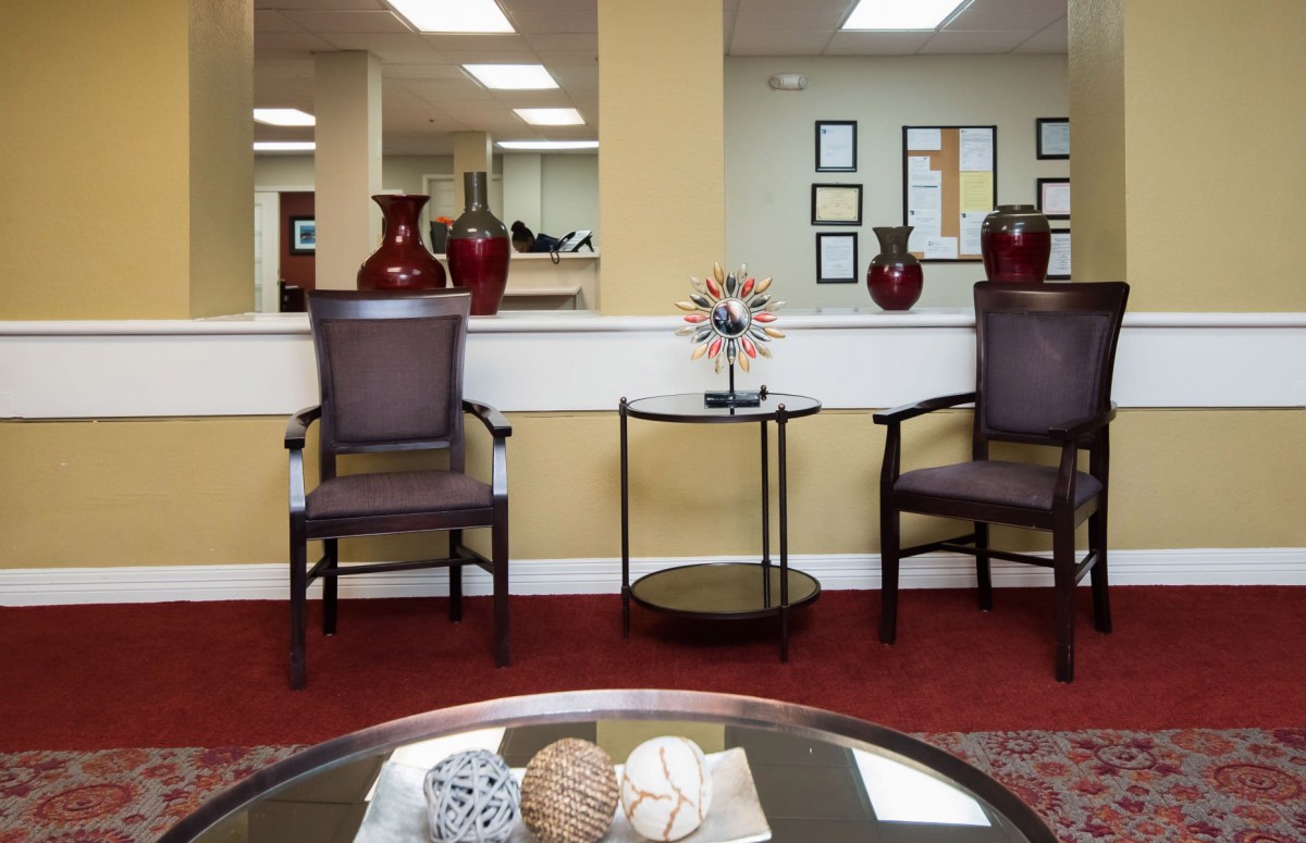A cozy waiting room with chairs, decorative vases, and a table centerpiece.