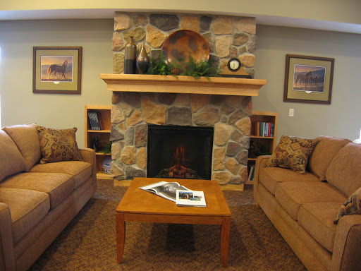 A comfortable living room featuring a stone fireplace, two sofas, and a wooden coffee table.