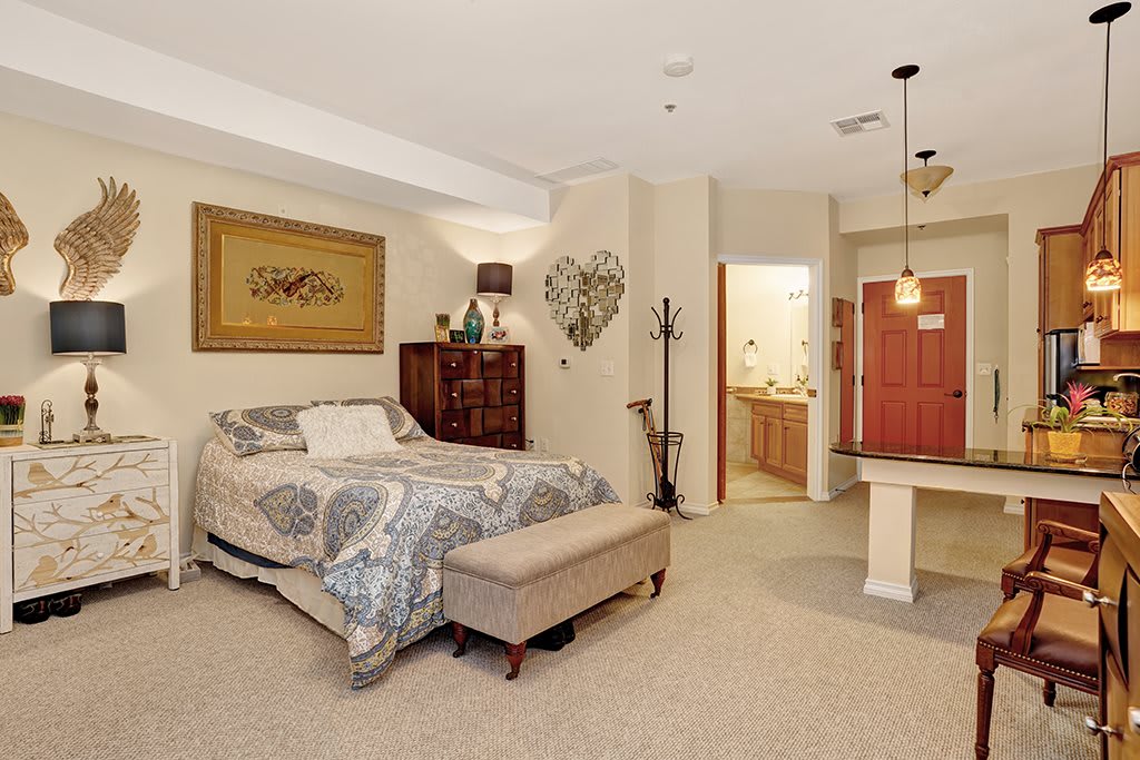A cozy bedroom featuring a comfortable bed, decorative wall art, and stylish lighting.
