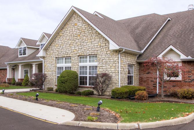A suburban house with a brick facade and well-maintained landscaping.