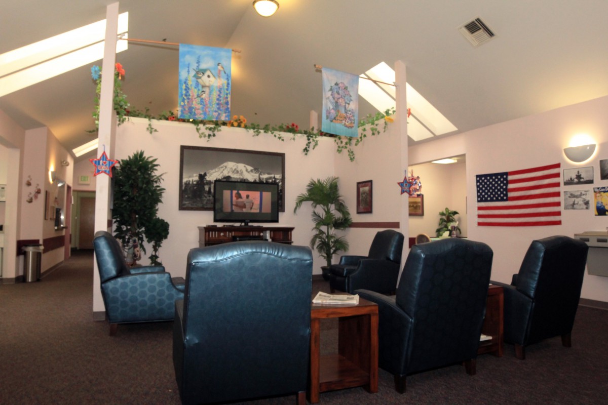A cozy lounge with comfortable seating, artwork on the walls, and decorative plants.
