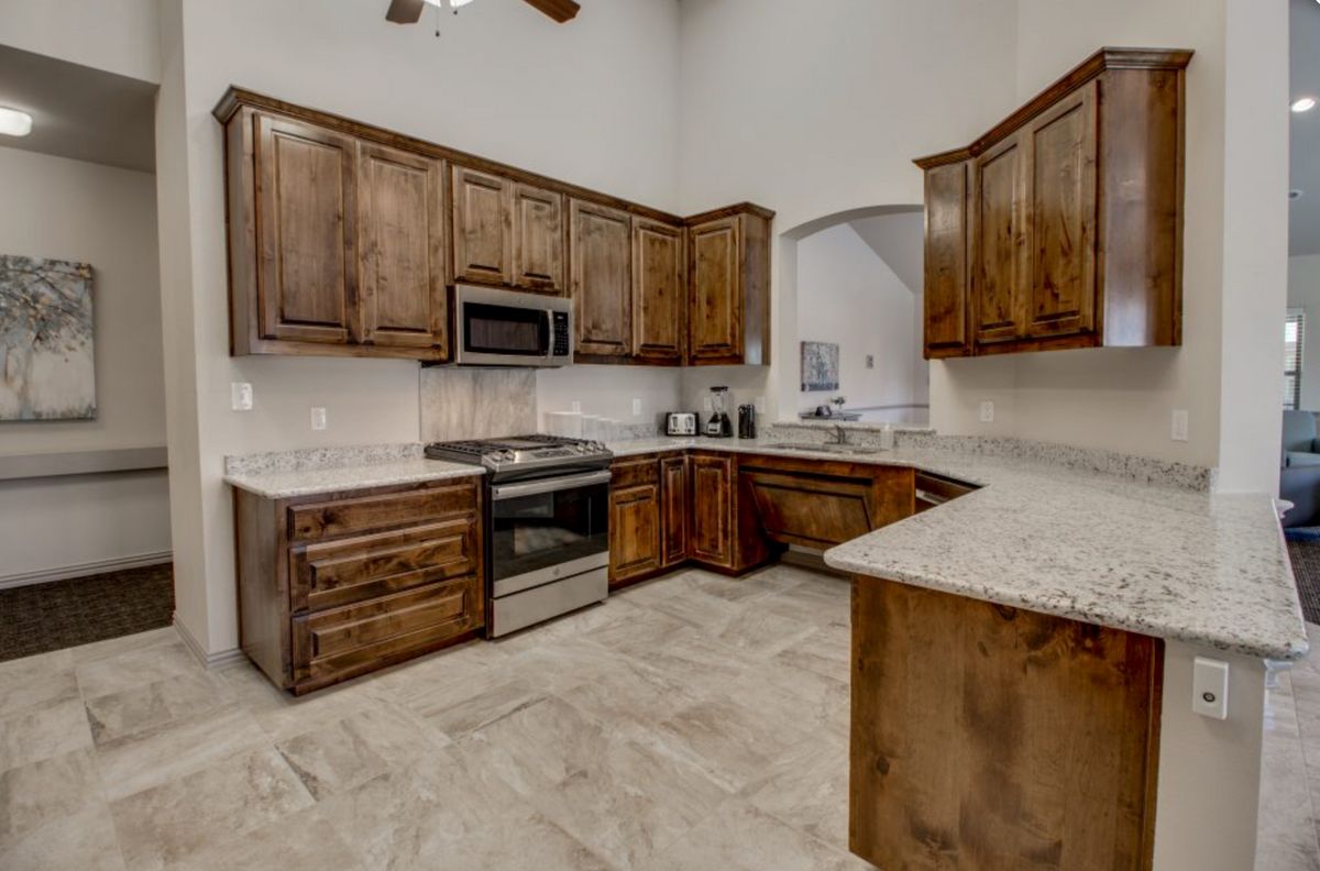 A modern kitchen with wooden cabinets and stainless steel appliances.