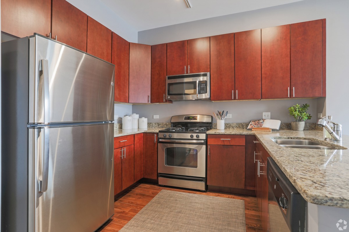 A modern kitchen with wooden cabinets and stainless steel appliances.