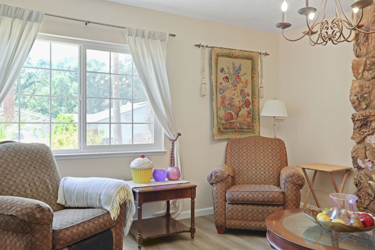 A cozy living room with an armchair, coffee table, and decorative wall art.