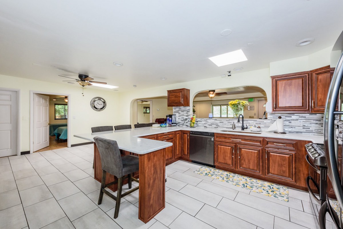 Spacious kitchen with wooden cabinets, a central island, and modern appliances.