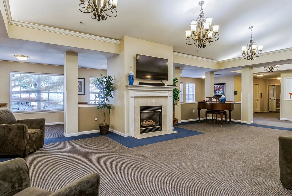 A cozy living room with a fireplace, chandeliers, and comfortable seating.