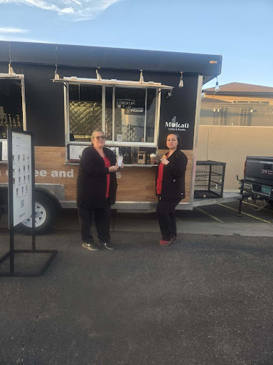 Two customers enjoying their experience at a food truck.