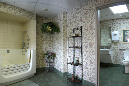 A cozy bathroom corner featuring floral wallpaper and decorative shelving.