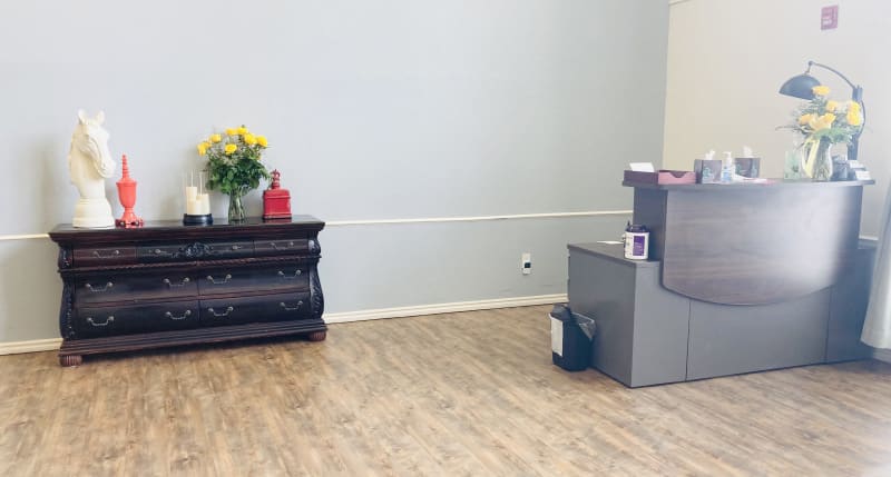 A minimalist waiting area with a reception desk and a decorative flower arrangement.