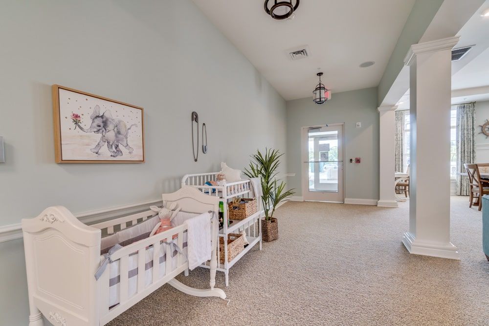 A spacious nursery featuring a crib and changing table, accented with soft pastel walls and an indoor plant.