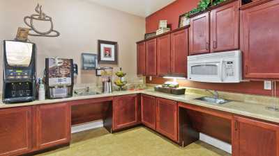 A cozy kitchen with wooden cabinets, a microwave, and a beverage dispenser.