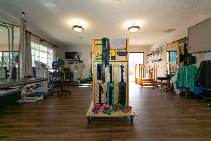 A well-equipped physical therapy room featuring various exercise tools and machines.