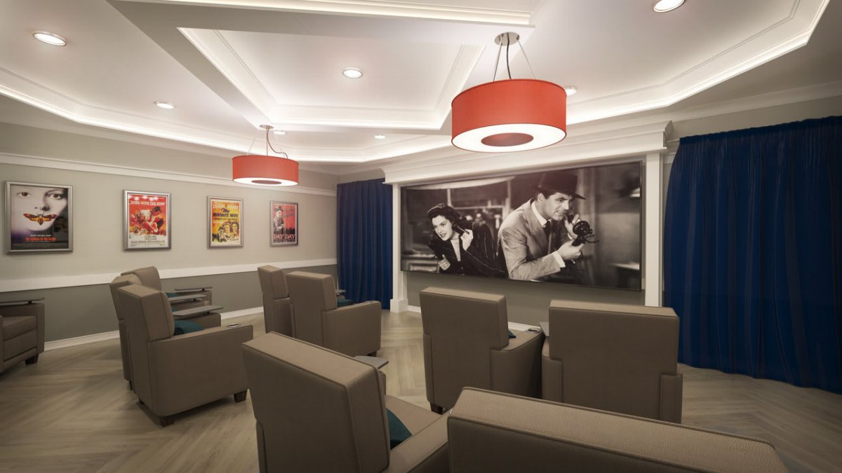 A modern home theater room with comfortable seating and stylish lighting, featuring a large projector screen and classic movie artwork on the walls.