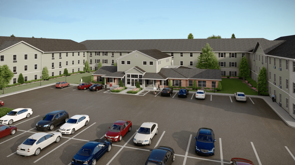 A residential building with a parking lot filled with various vehicles.