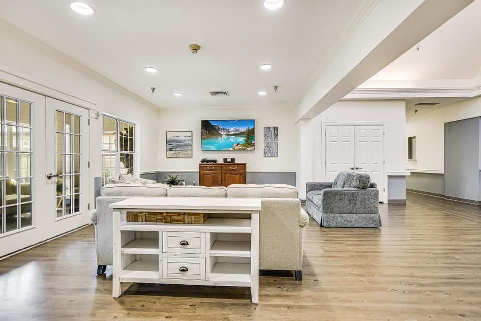 A modern and spacious living room with comfortable seating, a TV, and stylish decor.