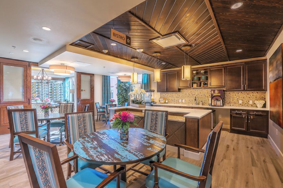 A modern open-plan kitchen and dining area with stylish wooden decor and lighting.