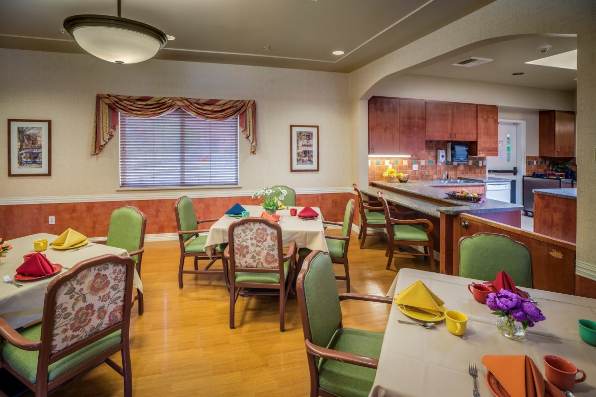 A cozy dining room with neatly arranged tables and chairs, set for a meal.