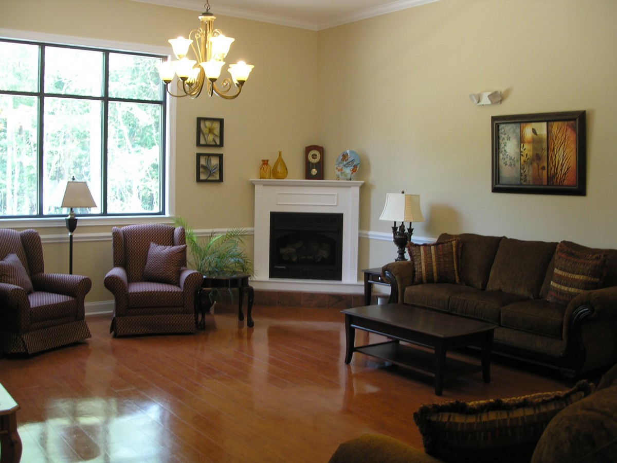 A cozy living room with a fireplace, sofas, and a chandelier.