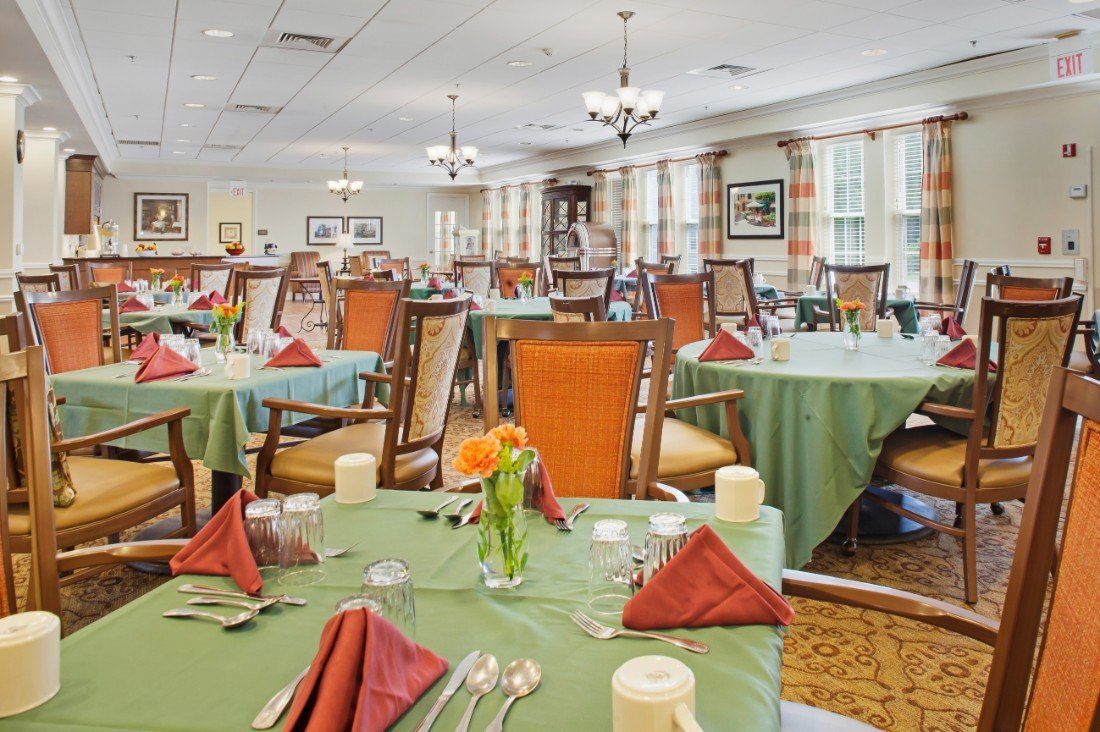 A well-decorated dining area with tables set for a meal, featuring neatly arranged napkins and elegant decor.