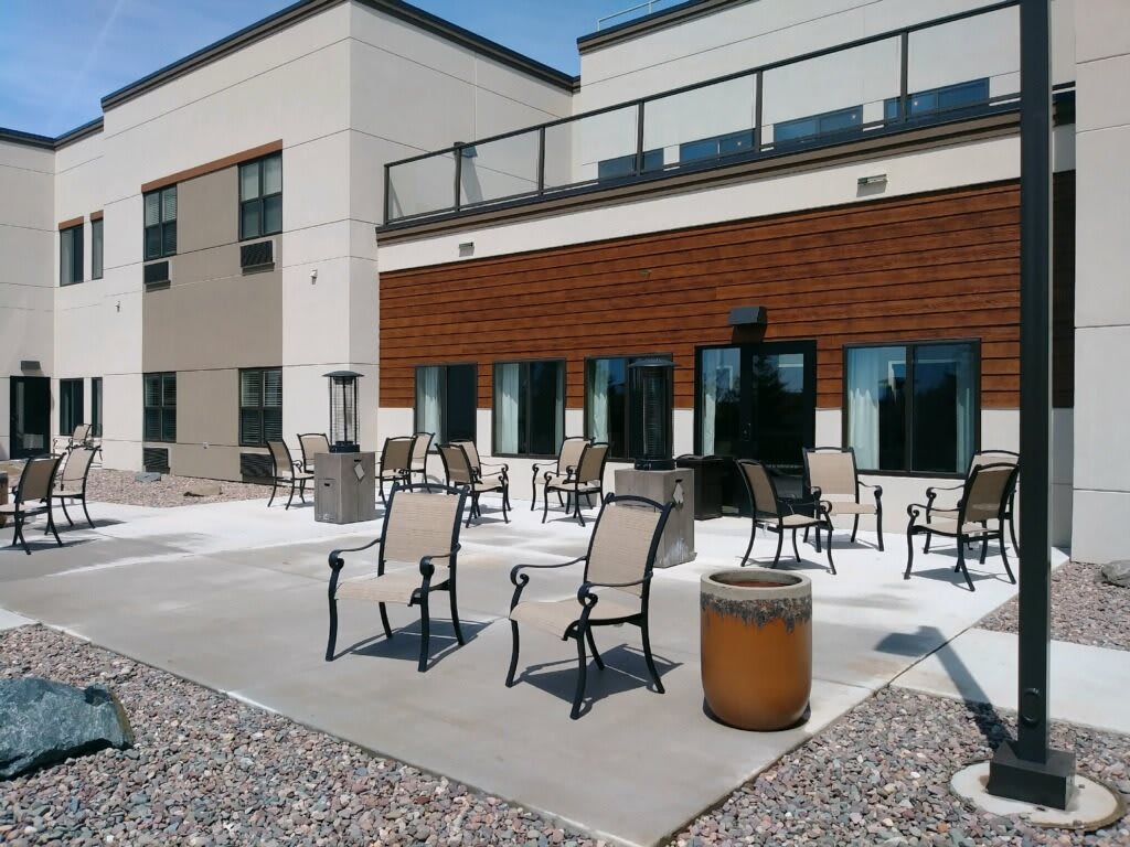 A modern outdoor patio area with chairs and tables on a sunny day.