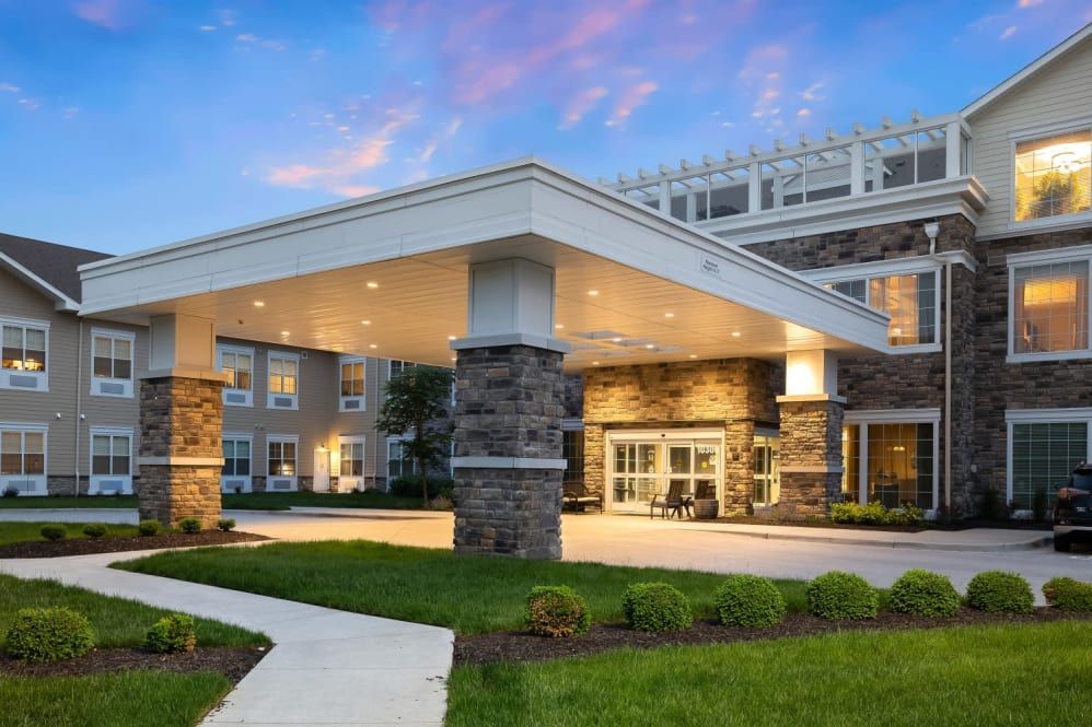 The exterior view of a modern building with a well-lit entrance and landscaped surroundings.
