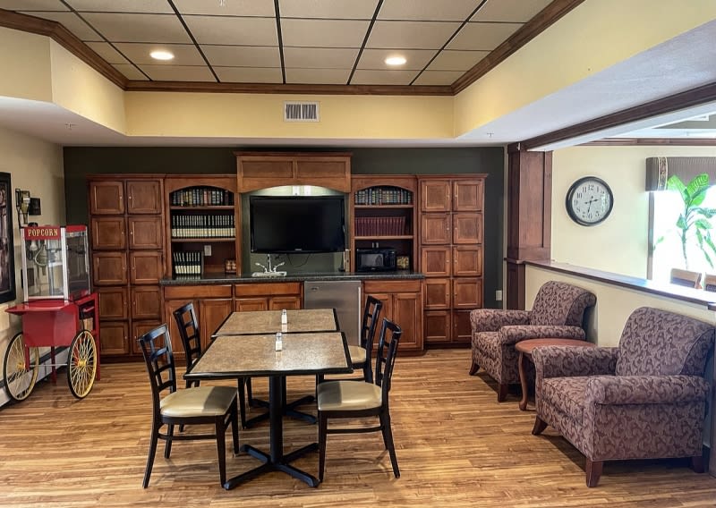 A cozy conference room with a table, chairs, and a television.