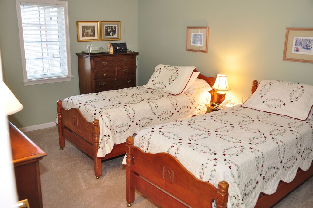 A cozy bedroom with twin beds and vintage decor.