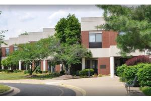 An exterior view of a building surrounded by trees and well-maintained landscaping.