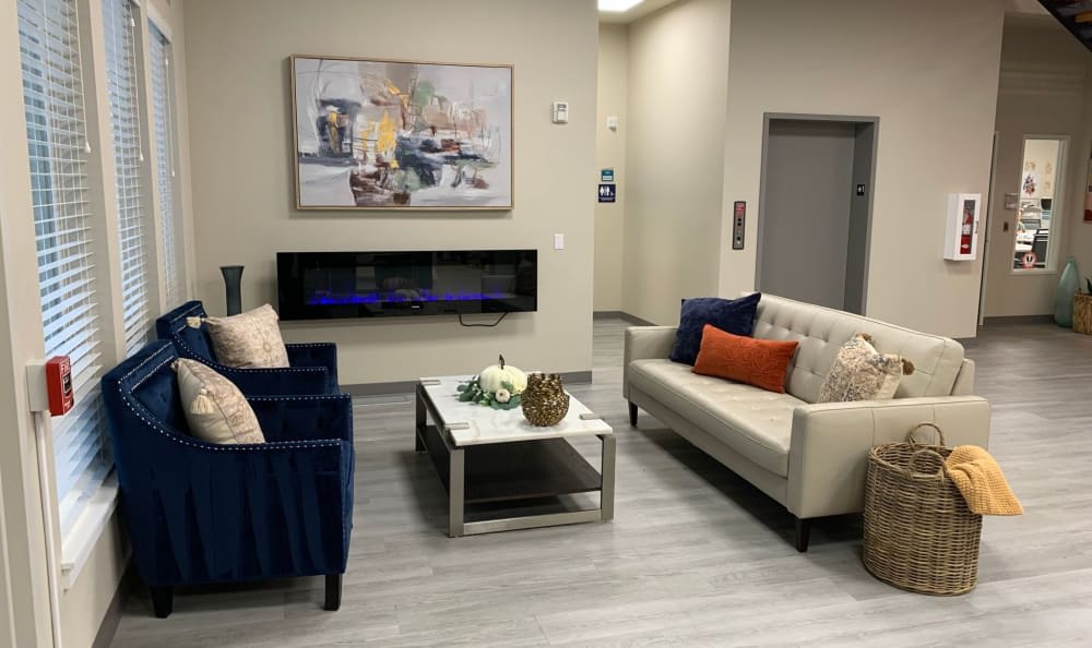 A modern living room with stylish furniture and a wall-mounted fireplace.