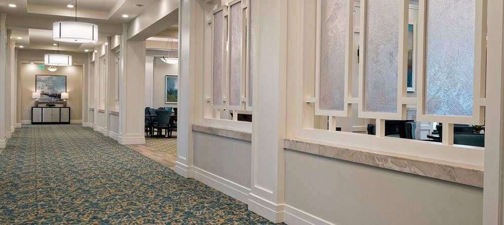 A well-lit hallway with elegant decor and patterned carpeting.