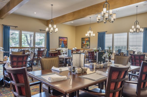 Cozy dining area with neatly arranged tables and elegant chandeliers.