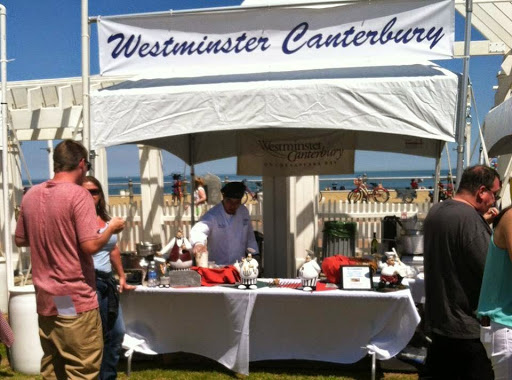 A bustling outdoor booth for Westminster Canterbury, showcasing a variety of offerings at an event.