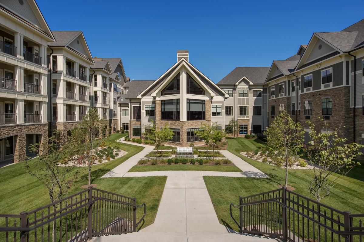 A modern apartment complex with landscaped courtyard and pathways.