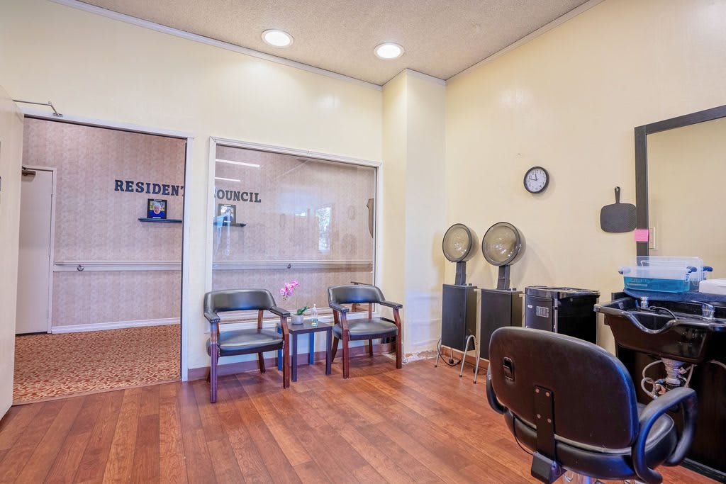 A cozy hair salon waiting area with comfortable chairs and vintage hair dryers.
