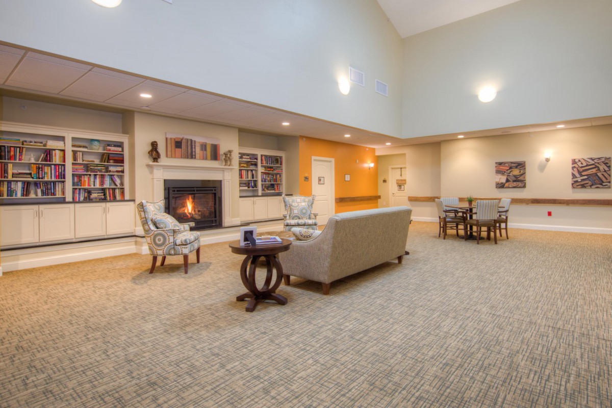A cozy lobby area featuring a fireplace, comfortable seating, and soft lighting.