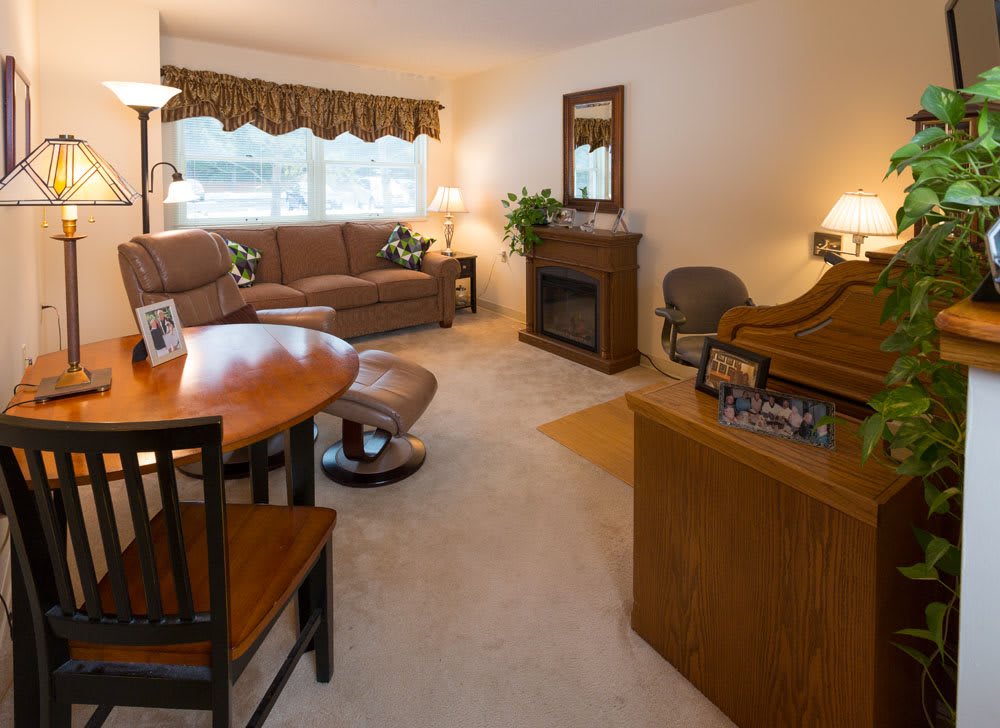 A cozy living room featuring a sectional sofa, coffee table, and dining area with warm lighting.