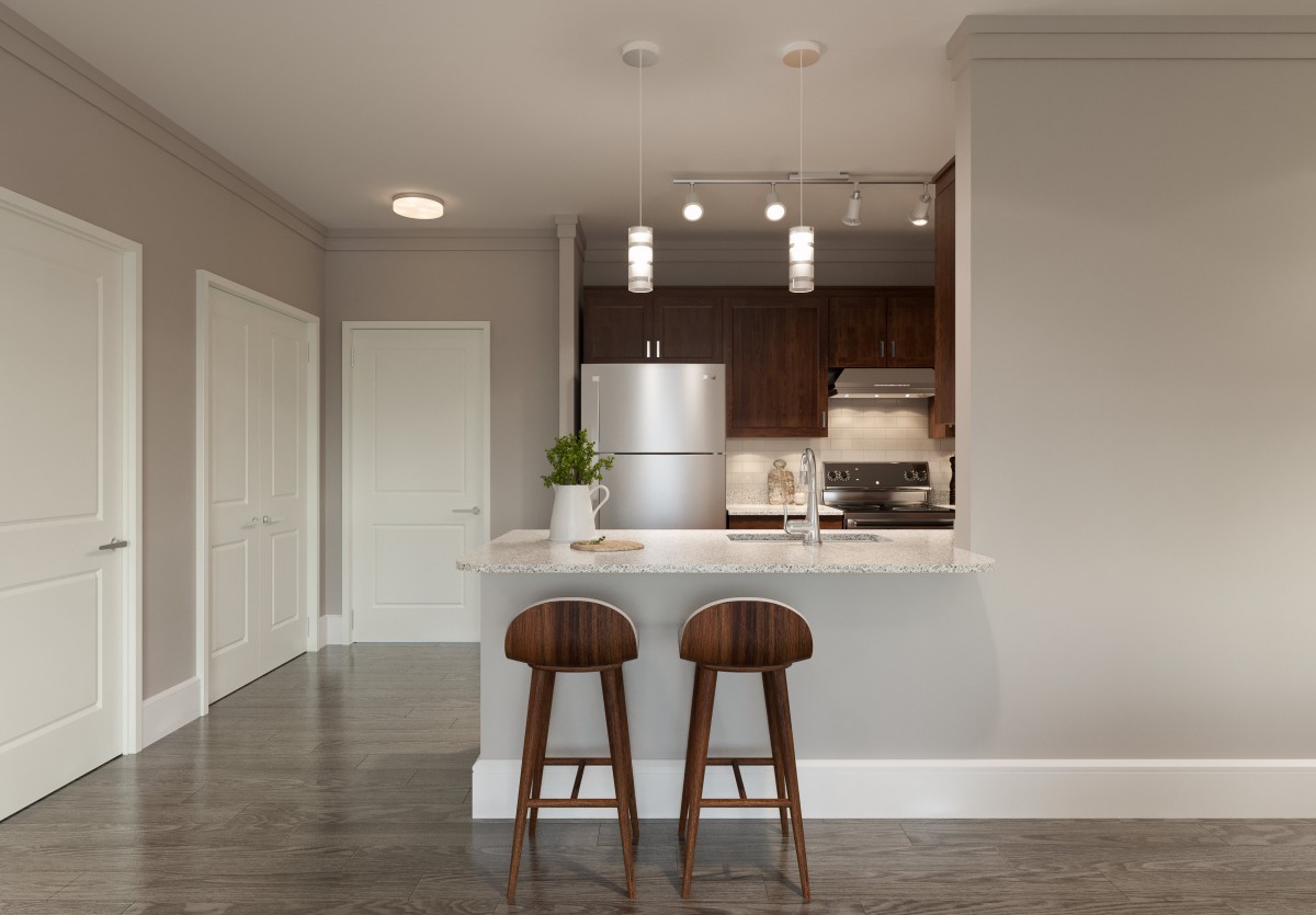 A modern kitchen with sleek design elements, featuring a stainless steel refrigerator and contemporary bar stools.