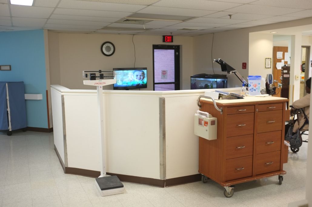 A nurse station in a hospital with medical equipment and computer monitors.