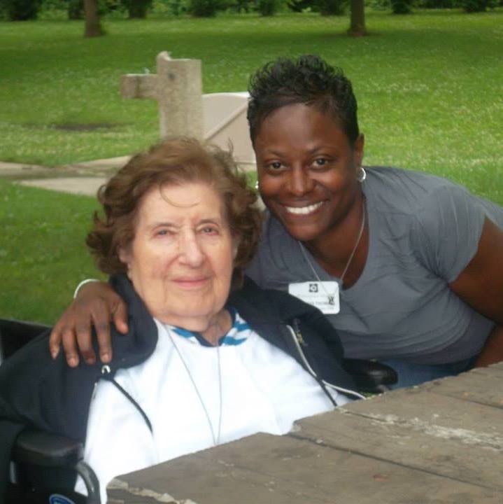 Two people enjoying time together outdoors, one sitting in a wheelchair.