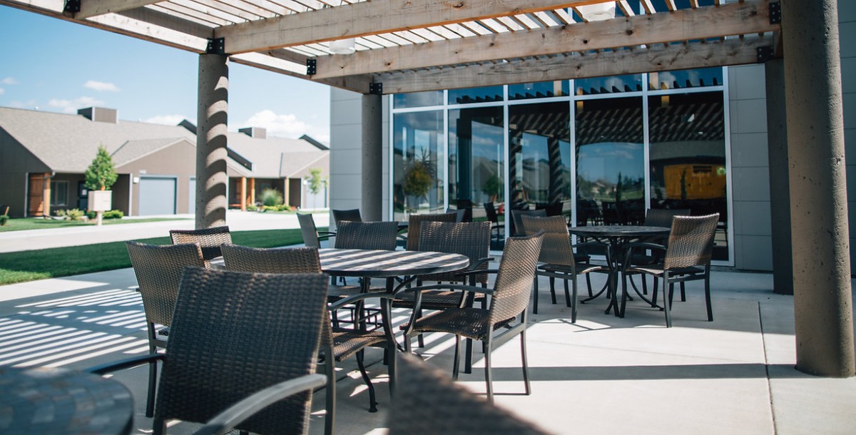 A sunny outdoor patio with tables and chairs, perfect for dining.