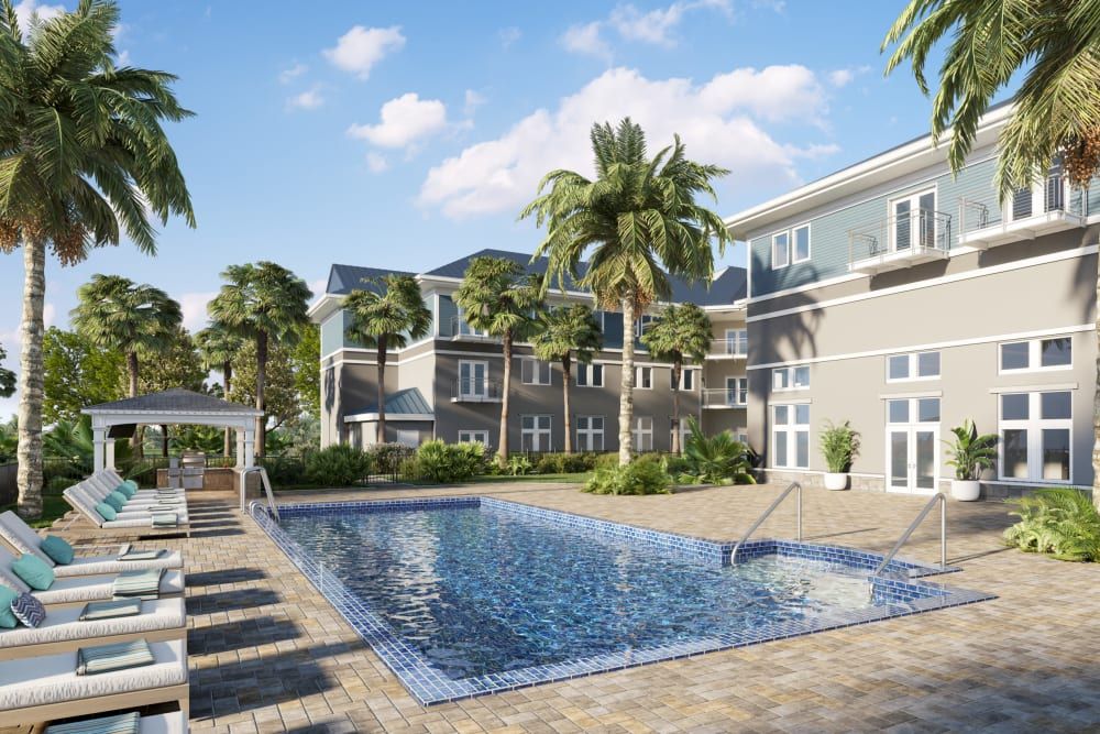 A serene residential area with a swimming pool surrounded by palm trees on a sunny day.