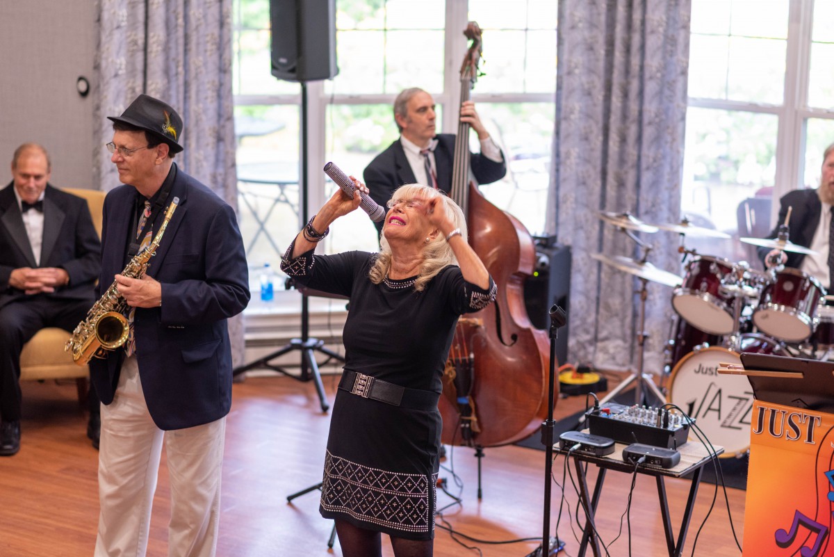 A band performing live with a singer and musicians playing various instruments.